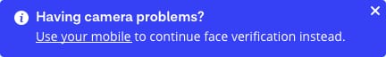 Desktop alert message reads 'Having camera problems? Use your mobile to continue face verification instead.' Two options available for user are 'Dismiss' or 'Use my mobile phone'